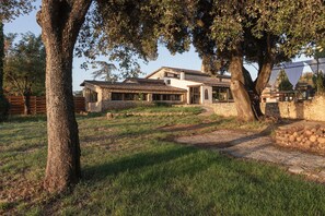 A stone house with a tiled roof, surrounded by trees and a grassy area. - La Sardagne | Charming House in the Heart of the Garrigue, Near Vallon-Pont-d'Arc (Bourg-Saint-Andéol)