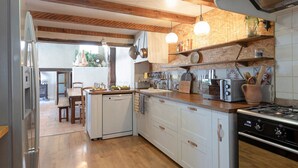 A kitchen with a central island, wooden cabinets, a built-in oven, and a stove. - La Sardagne | Charming House in the Heart of the Garrigue, Near Vallon-Pont-d'Arc (Bourg-Saint-Andéol)
