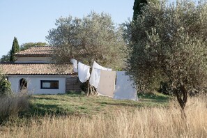 A house with a tiled roof, a small window, and clothes hanging on a line. - La Sardagne | Charming House in the Heart of the Garrigue, Near Vallon-Pont-d'Arc (Bourg-Saint-Andéol)