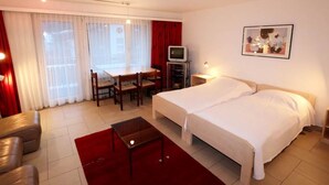 A hotel room with a bed, a desk, a chair, a television, and a painting on the wall. - Sarazena Appartement/Fewo 2-Bettwohnung N by Interhome (Saas-Fee)