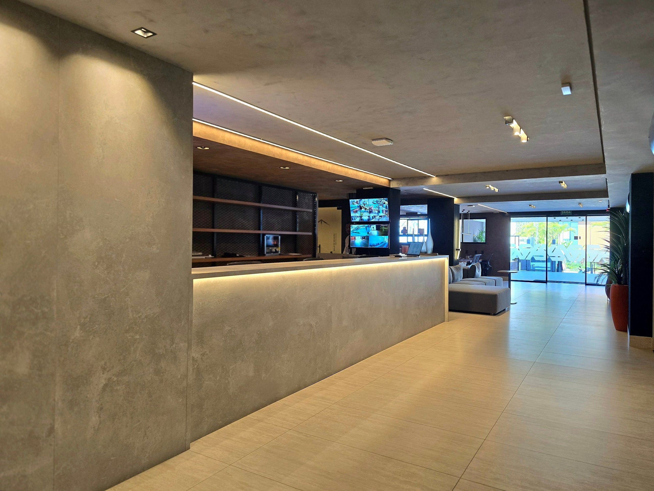 Un área de recepción moderna con mostrador, asientos y vistas al exterior.