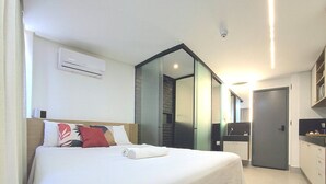 Una habitación de hotel con cama, baño y kitchenette.