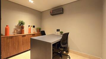 Un espacio de oficina moderno con un escritorio, una silla y un armario de madera.