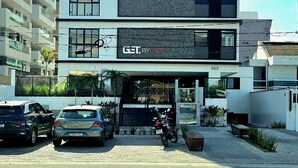Un edificio de varios pisos con una fachada que indica 'GET BY SIDE' y una motocicleta estacionada frente.