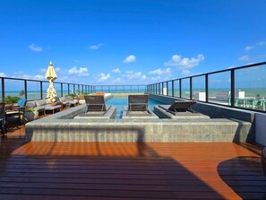 A rooftop pool area with lounge chairs and a view of the ocean. - Get By Side By Hosppedar (João Pessoa)