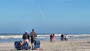 A beach scene with people, chairs, and a jet trail. - BEACHFRONT! Beautiful pool, hot tub, tennis, pickle &LOTS of restaurants nearby! (St. Augustine)