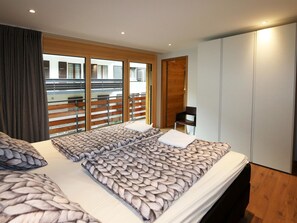 Une chambre d’hôtel avec un grand lit, une armoire et une vue sur le balcon extérieur.