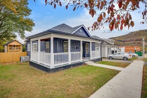 A two-story house with a porch, a fenced yard, and a car parked in the driveway. - Blue Haven in Erwin, TN (Erwin)