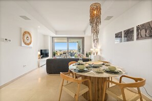 Ein stilvoller Essbereich mit einem runden Tisch, Stühlen und Blick auf die Skyline durch große Fenster.