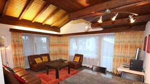 Ein modernes Wohnzimmer mit einem Glastisch, Ledersofas und einem Essbereich mit einem Glastisch.