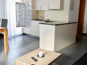Eine moderne Küche mit einer zentralen Kochinsel, einem Essbereich mit Tisch und einer Kücheninsel mit Spüle.
