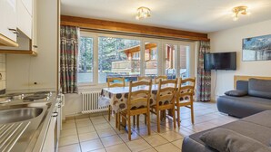 Eine moderne Küche mit Essbereich, einer Couch und einem Fernseher.