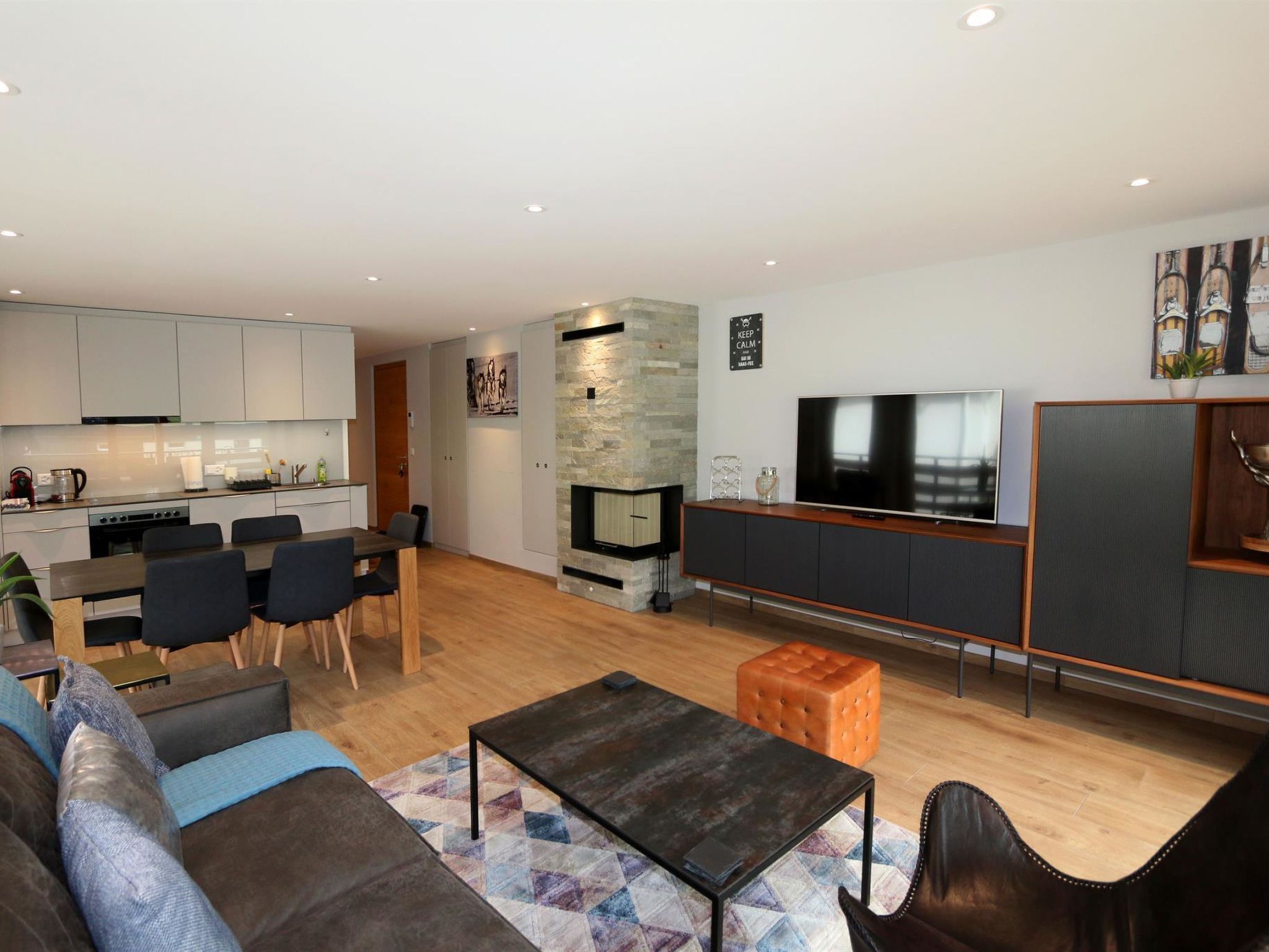 Ein modernes Wohnzimmer mit einer Couch, einem Couchtisch und einem Fernseher.