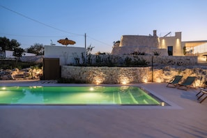 Una piscina al aire libre de temporada, sombrillas, tumbonas