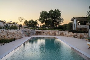 Una piscina al aire libre de temporada, sombrillas