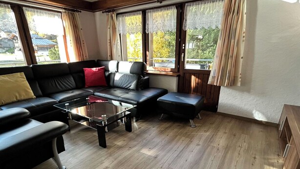A modern living room with a black leather sofa, a glass coffee table, and wooden flooring. - Sunstar Appartement/Fewo 8-Bettwohnung Nr. 41 by Interhome (Saas-Grund)