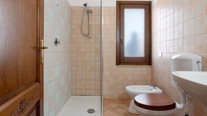 Un baño con ducha, inodoro y lavabo.