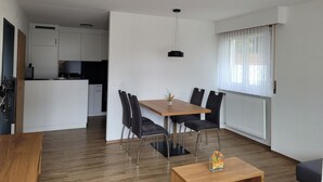 Un appartamento moderno con zona pranzo, cucina e soggiorno.