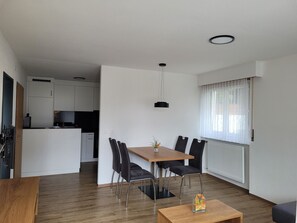 A modern apartment with a dining area, kitchen, and a living space. - Haus Perle Appartement/Fewo 3-Bettwohnung Nr. 2 by Interhome (Saas-Fee)