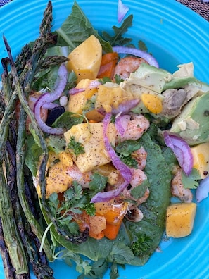 A salad with various vegetables and a blue plate.