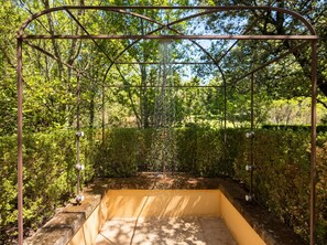 A metal pergola structure with a water feature in a garden setting. - Provence Bastide XVIIIe Moderne, Calme, 10mn d'Aix - Ste-Victoire (Vauvenargues)
