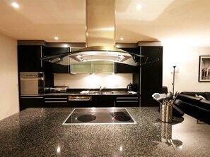 A modern kitchen with a central island, built-in oven, and stainless steel appliances. - Nicoletta Appartement/Fewo 8-Bettwohnung by Interhome (Saas-Fee)