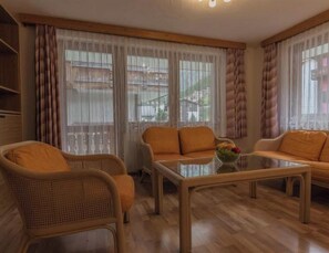 A furnished living room with wicker chairs, a glass coffee table, and a sofa. - Bergfink Appartement/Fewo 4-Bettwohnung Nr. 3 by Interhome (Saas-Fee)