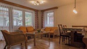 A furnished living room with a sofa set, a coffee table, and a dining table with chairs. - Bergfink Appartement/Fewo 4-Bettwohnung Nr. 3 by Interhome (Saas-Fee)