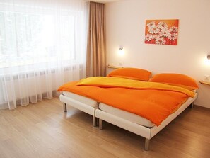 A bedroom with a bed, curtains, a painting, and a window. - Adonis Appartement/Fewo, Dusche oder Bad, WC 4-Bettwohnung by Interhome (Saas-Fee)