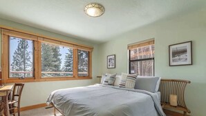A bedroom with a large bed, two windows, a desk, and a chair. - Tahoe Vista Getaway: Lake View & Hot Tub & Deck (Tahoe Vista)