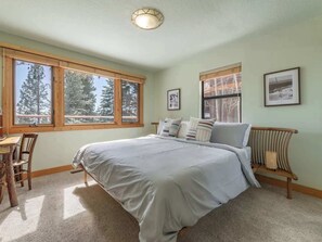 A bedroom with a large bed, two windows, a desk, and a chair. - Tahoe Vista Getaway: Lake View & Hot Tub & Deck (Tahoe Vista)
