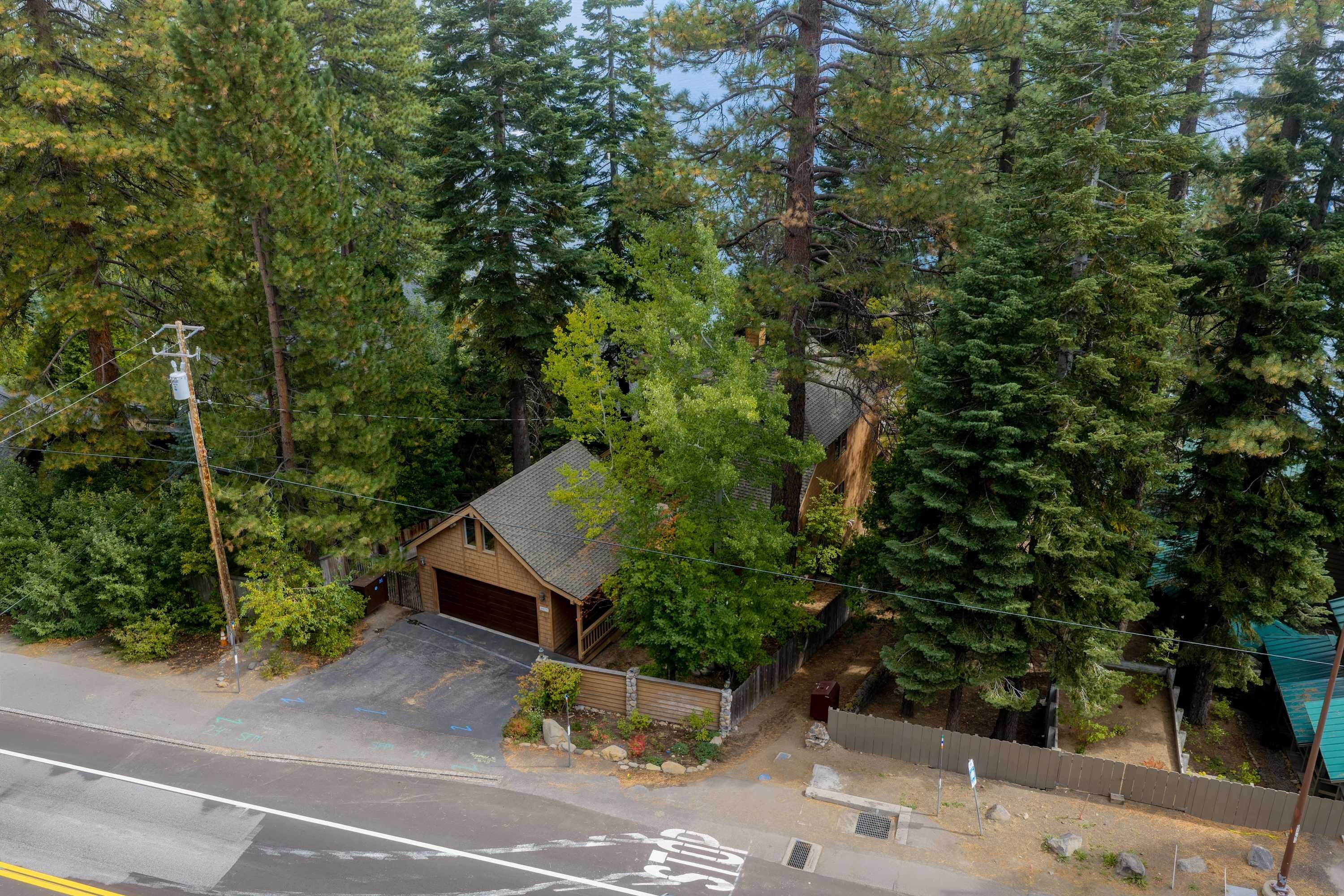 Une petite cabane avec un garage, entourée d’une forêt dense.