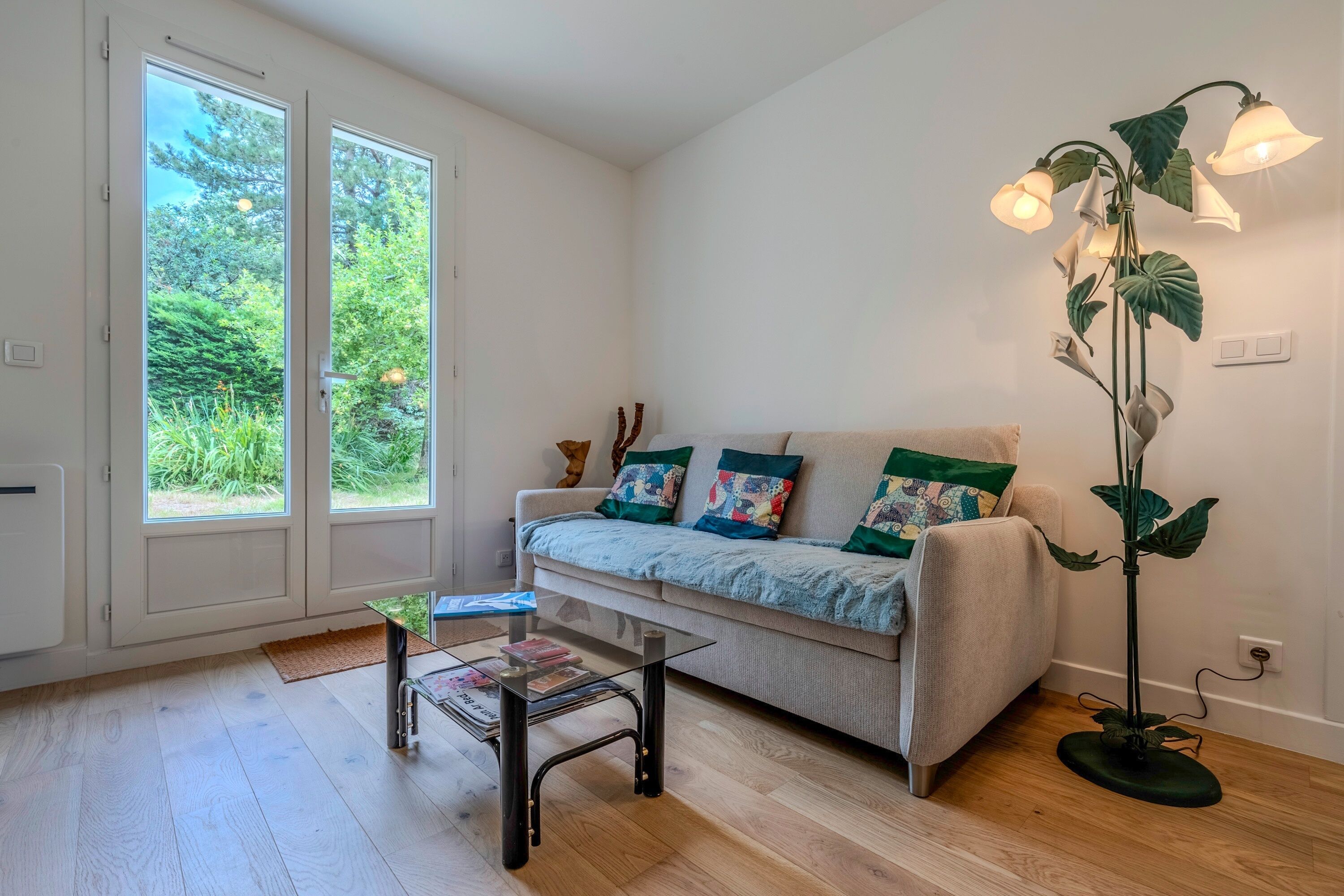 Un salon avec un canapé, une table basse et un lampadaire.