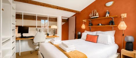 Ein Schlafzimmer mit Bett, Schreibtisch, Stuhl und Kleiderschrank.