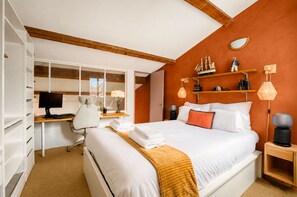 Un dormitorio con cama, escritorio, silla y armario.