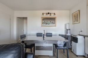Ein Essbereich mit Tisch, Stühlen, einem Gemälde und einer Heizung.