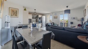 A modern living space with a dining area, kitchen, and seating area. - Les Terrasses de Michelle - Dune du Pilat à 15min (La Teste-de-Buch)