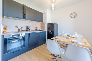 Eine moderne Küche mit Backofen, Kaffeemaschine und Kühlschrank.