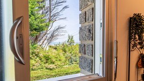 Una finestra amb vista a un jardí i un cel clar.