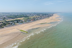 An aerial view of a coastal area with a sandy beach, a promenade, and residential buildings. - L'Écho des Marées - Bernières-sur-Mer (Bernières-sur-Mer)