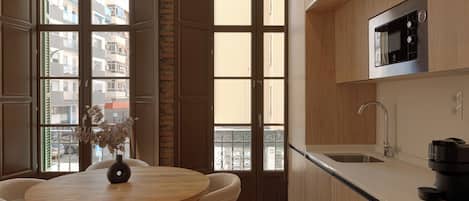 Una cocina moderna con comedor, ventanas amplias y vista a la ciudad.