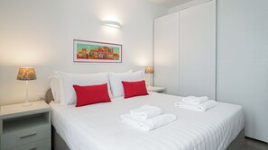 Ein Hotelzimmer mit einem Bett, zwei Nachttischen, einer Wandlampe und einem gerahmten Bild.
