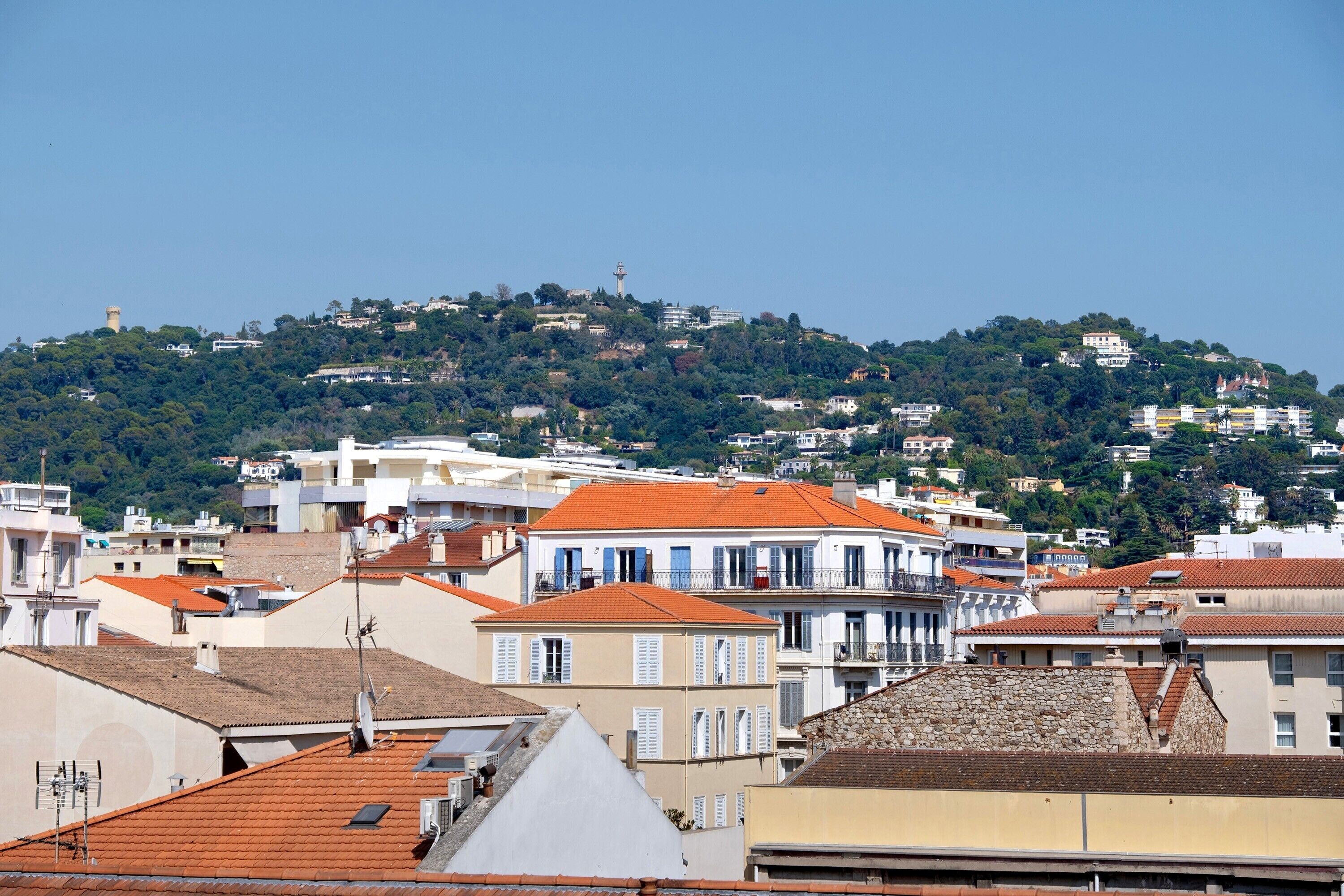 A coastal town with buildings on a hillside, including a lighthouse.