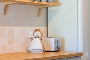 A kitchen with a kettle, toaster, and wooden shelf. - Villa Marius, fully renovated, walking distance to the village, A/C, pool (Saint-Rémy-de-Provence)