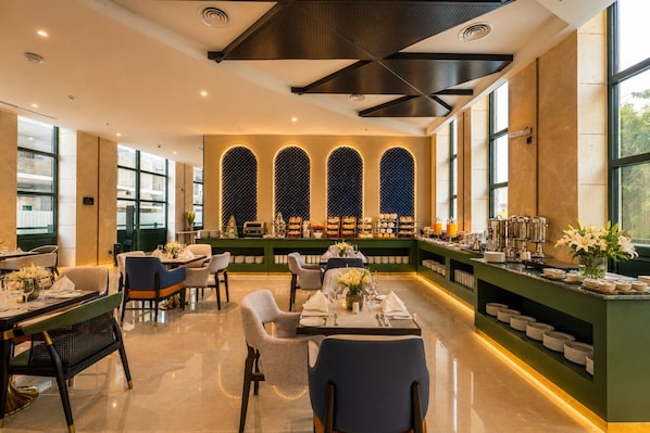 A modern dining area with a buffet setup, including a variety of food items and a selection of beverages.