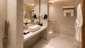 A modern bathroom with a large mirror, a sink, and a shower area. - Naviti By Warwick Jeddah (Al Quwaiiyah)
