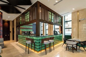 Un café moderno con barra, mesas y vistas a la calle.