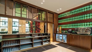 A bar area with shelves of glasses and a coffee machine. - Naviti By Warwick Jeddah (Al Quwaiiyah)