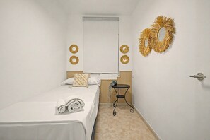 Ein Hotelzimmer mit einem Bett, einem kleinen Tisch, einem Spiegel und dekorativen Wandgestaltungen.