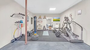 Ein Fitnessstudio mit Trainingsgeräten, einer Säule und einem Spiegel.